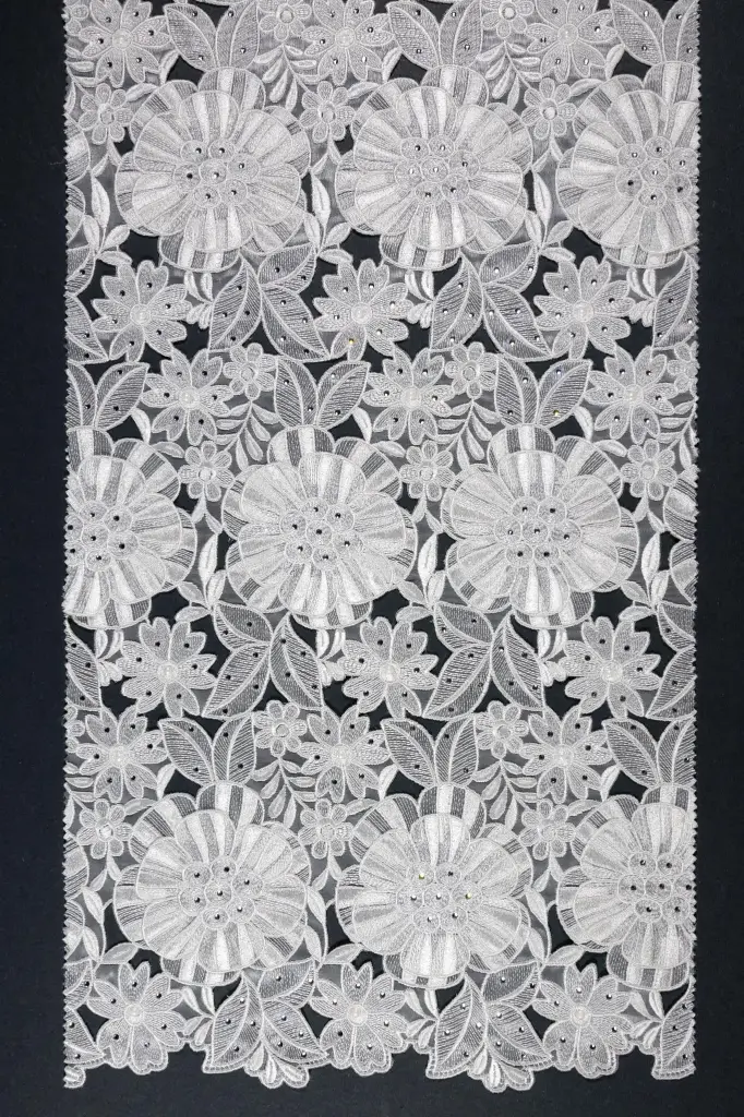 Embroidered allover with sewed on motifs 